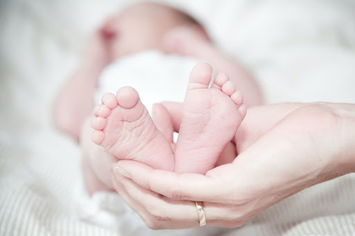 Hand holding feet of newborn baby