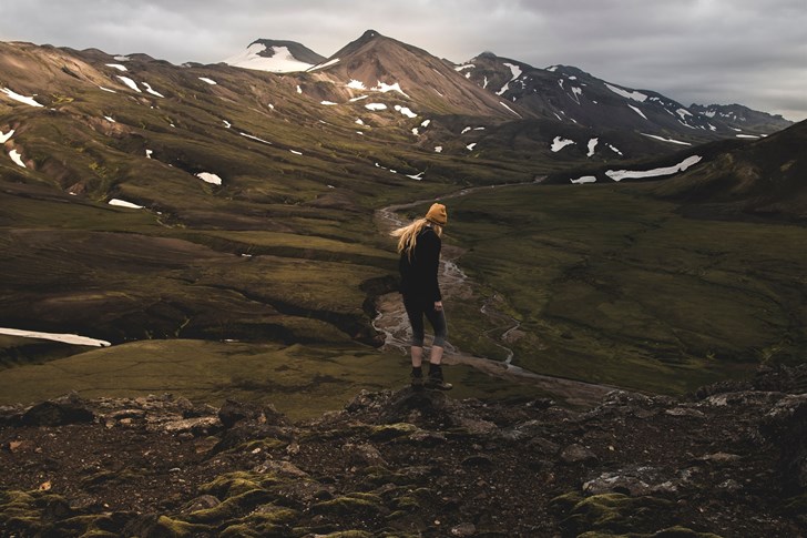 Woman hiking over rocks in the Icelandic highlands.