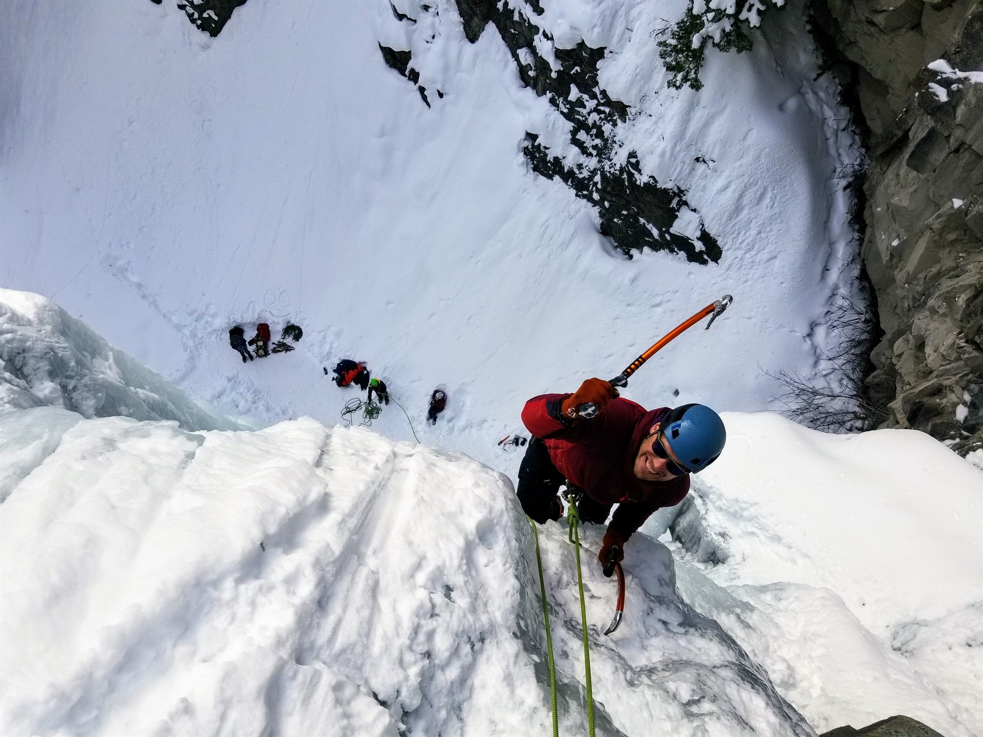 Man climbing up a snow-covered ice face in Iceland.