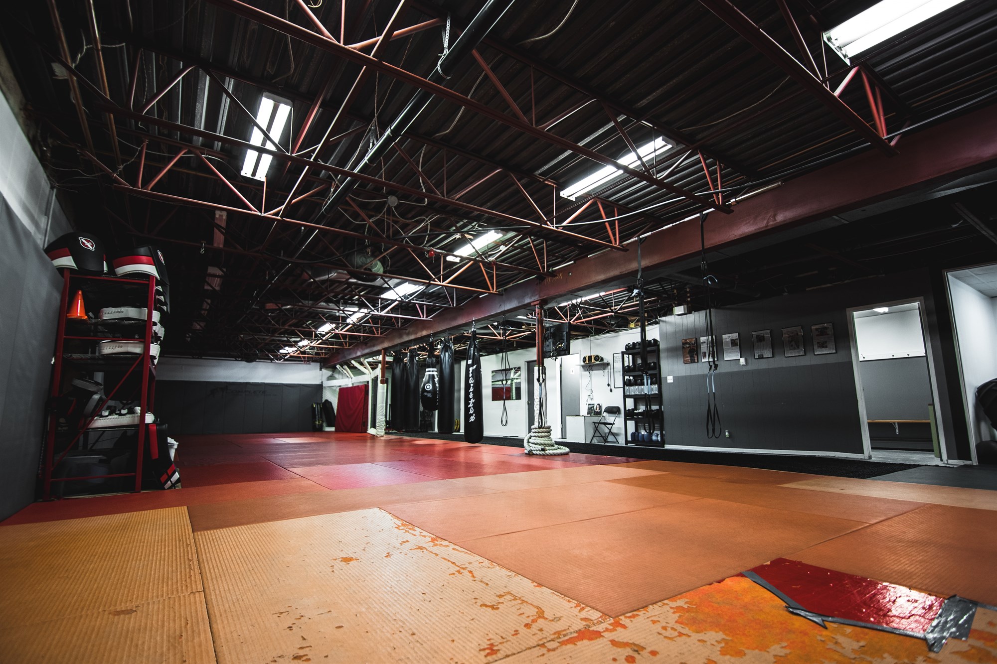 Training gym indoors with red floor for sporting activities.