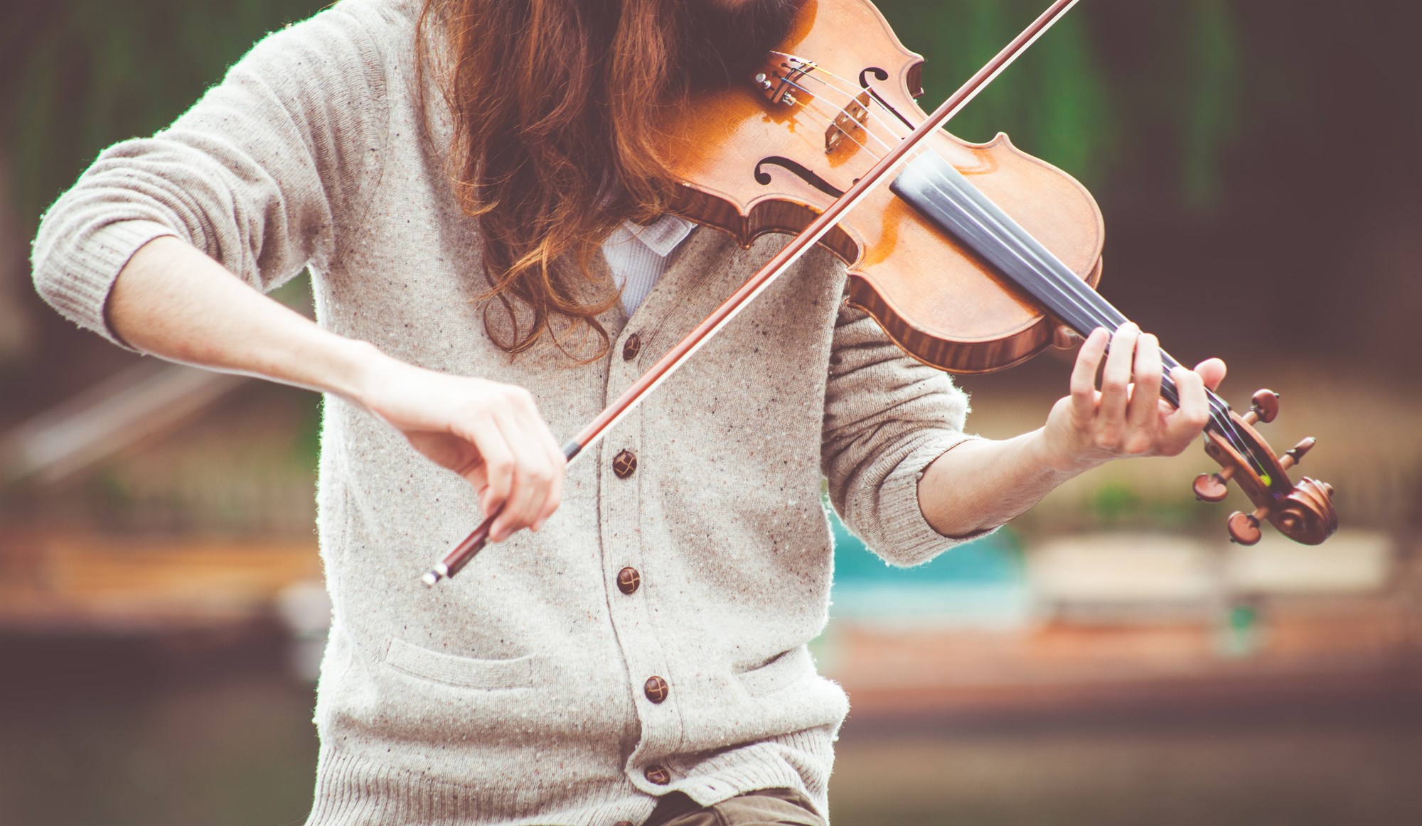 Person playing folk music on a violin.