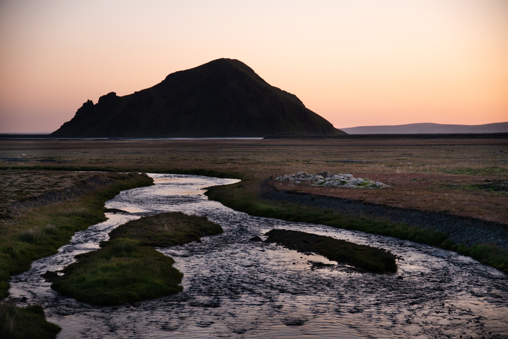 Midnight sun over the silhouettes of mountains in northern Iceland.