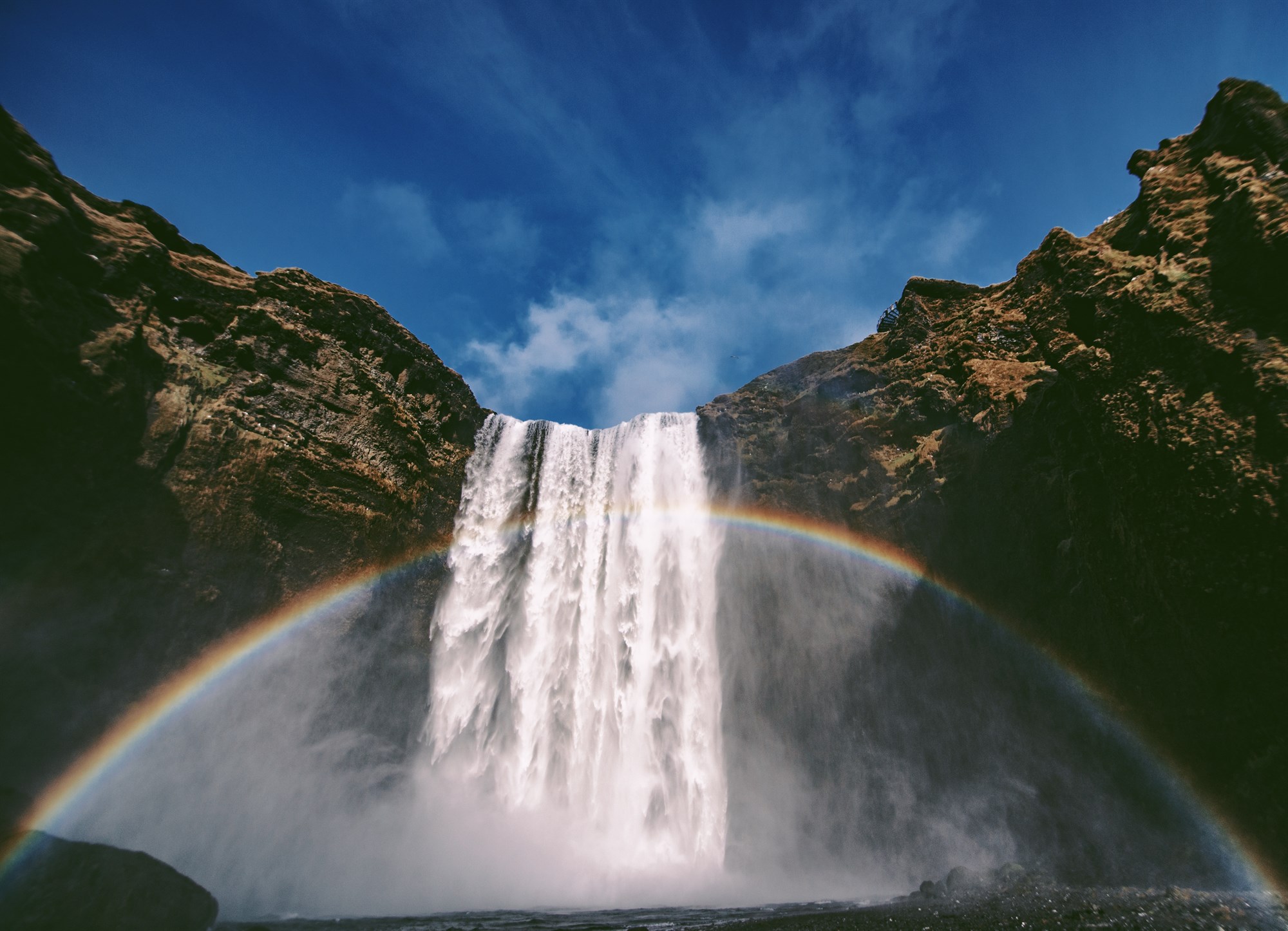Rainbow of light infront of Skogafoss waterfall, Iceland.