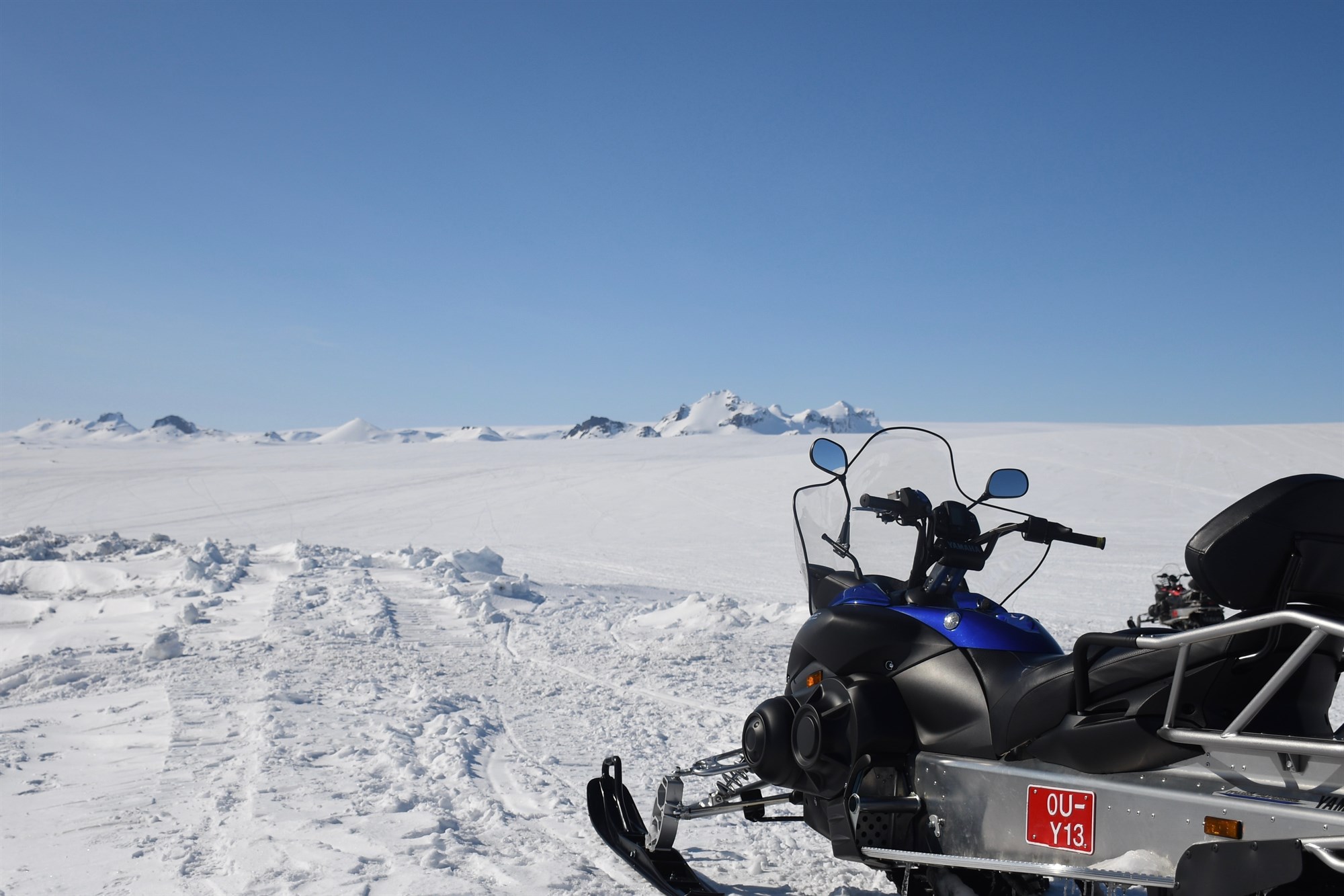  Snowmobile on Iceland snow with blue skies overhead.